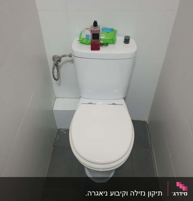 אסלה עם צינור מים מחובר לקיר